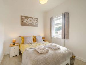 a bedroom with a bed with two towels on it at 2 Bed in Portreath 88826 in Camborne