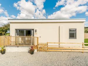 a small white house with a wooden fence at 2 Bed in Portreath 88826 in Camborne