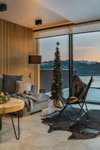 a living room with a christmas tree and a couch at Apartamenty nad jeziorem, Czorsztyn - Kluszkowce in Czorsztyn