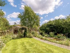 un jardin avec une pelouse, des arbres et une maison dans l'établissement 1 Bed in Stanton Lees 89283, à Stanton in Peak