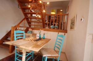 uma sala de jantar com uma mesa de madeira e cadeiras azuis em Het Molenaarshuis em Thorn