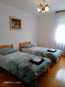 1 dormitorio con 2 camas y lámpara de araña en Apartma Bomar, en Koper
