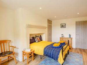 um quarto com uma cama amarela e uma cadeira em 2 bed in Ilkley 89554 em Ilkley