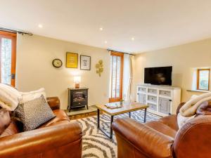 a living room with a leather couch and a television at 2 Bed in Holsworthy GMEAD in Sutcombe