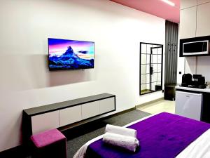 a bedroom with a bed and a tv on a wall at Apartments Almatau in Taldykolʼ