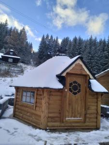 Cabaña de madera con nieve en el techo en Ubytování pod Rozhlednou, en Velké Karlovice