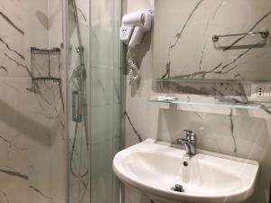 La salle de bains est pourvue d'un lavabo et d'une douche. dans l'établissement Hostel Cosmos, à Rome