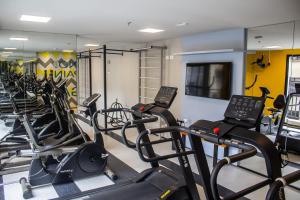 a gym with rows of treadmills and cardio machines at Studio no centro de Curitiba in Curitiba