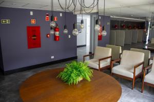a waiting room with a table and chairs and a red box at Studio no centro de Curitiba in Curitiba