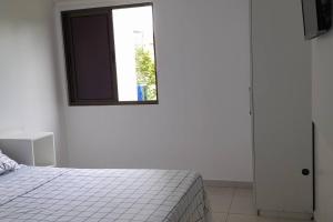 a white bedroom with a bed and a window at Lindo Flat no Carneiros Beach Resort in Tamandaré