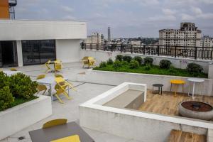 a rooftop patio with tables and chairs on a building at Studio no centro de Curitiba in Curitiba