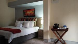 a hotel room with a bed and a night stand at Forest House B&B in Harding