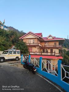 a house with a motorcycle parked in front of it at RKD HOMESTAY in Kurseong