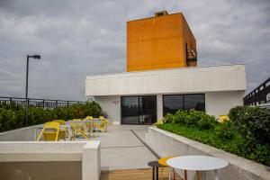 a building with yellow chairs and tables on a patio at Studio no centro de Curitiba in Curitiba