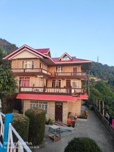 a large brick house with a balcony on a hill at RKD HOMESTAY in Kurseong