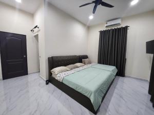 een slaapkamer met een bed en een plafondventilator bij Restu Villa Homestay in Tuaran