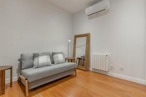 a living room with a couch and a mirror at Wide Stylish-1Bedroom 1Bathroom-Las Letras in Madrid