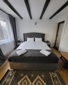 a bedroom with a large bed with two towels on it at Adac Boutique Hotel in Bucharest