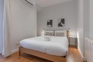 a bedroom with a large white bed with two teddy bears on it at Wide Stylish-1Bedroom 1Bathroom-Las Letras in Madrid