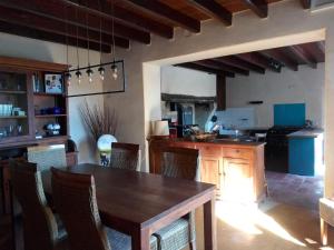 cocina con mesa de madera y sillas en Le Chapelat, en Saint-Michel-Saint-Jaymes