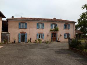 une grande maison dotée de fenêtres bleues et d'une allée. dans l'établissement Le Chapelat, à Saint-Michel-Saint-Jaymes