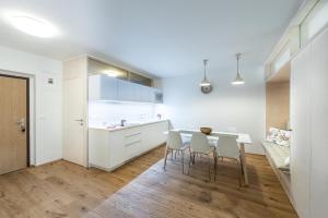 a kitchen with white cabinets and a table and chairs at Castle Wall Apartment in Bratislava