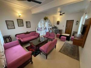 a living room with pink couches and a table at Alinda House Naukuchiatal by THE GHAUR in Bhīm Tāl