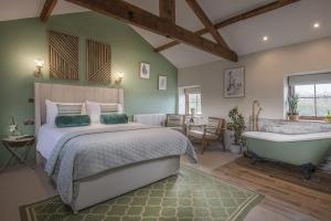 een slaapkamer met een bed en een bad bij The Granary at Fawsley in Daventry