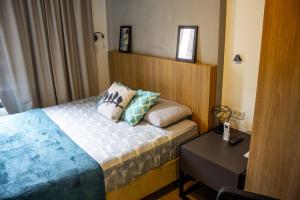 a hotel room with a bed and a table at Studio no centro de Curitiba in Curitiba