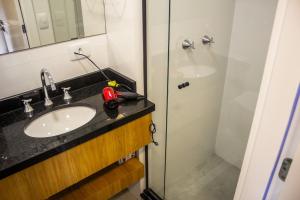 La salle de bains est pourvue d'un lavabo et d'une douche. dans l'établissement Studio no centro de Curitiba, à Curitiba