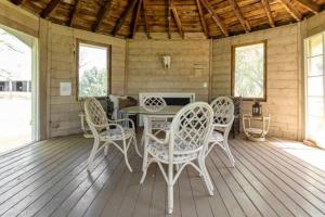 um alpendre de um chalé com uma mesa e cadeiras em Charming & Rustic Bloomingdale Cottage w/views 