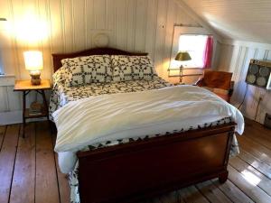 um quarto com uma cama grande e piso em madeira em Charming & Rustic Bloomingdale Cottage w/views 