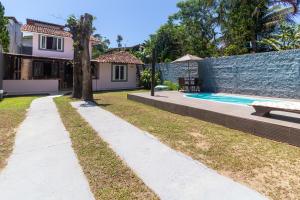 un patio trasero con piscina y una casa en Suítes Valdira, en Arraial d'Ajuda