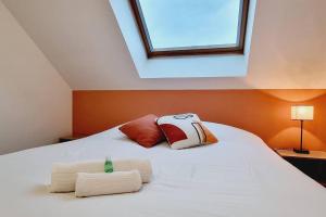 un letto bianco con due cuscini e una finestra di *l'Oasis du Cœur de Ville*Spacieux et moderne a Gravelines Altre 51 foto