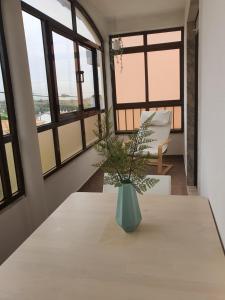 a vase sitting on a table in a room with windows at Hospedagem Emanuel in Caneças