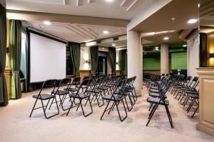 a room with a bunch of chairs and a screen at Dnipro Hotel in Kyiv