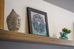 a statue sitting on a shelf with a picture at Studio no centro de Curitiba in Curitiba