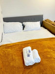 a bed with two towels sitting on top of it at Ebehi Inn in London