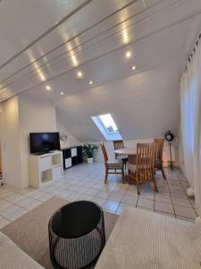 ein Wohnzimmer mit Tisch, Stühlen und Fernseher in der Unterkunft FeWo Sundernblick in Haltern