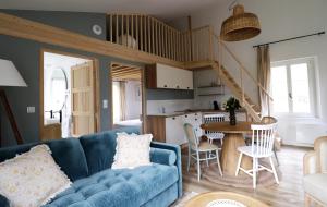 a living room with a blue couch and a table at Le Domaine Saint Ange in Friville-Escarbotin
