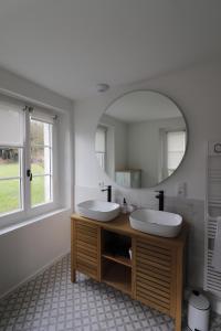 un bagno con due lavandini e un grande specchio di Le Domaine Saint Ange a Friville-Escarbotin