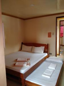 a bedroom with two beds with towels on them at D'MESA Seacretlodge and Restaurant in Taytay