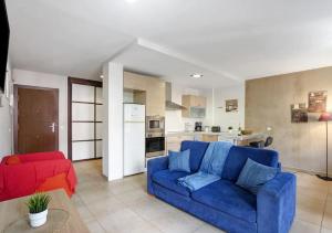 a living room with a blue couch and a kitchen at LOVE ISLAND 77 in Palm-mar