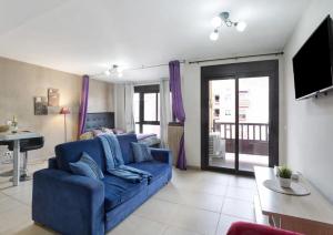 a living room with a blue couch and a table at LOVE ISLAND 77 in Palm-mar