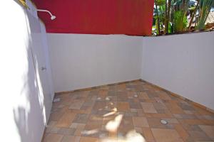 een kamer met een witte muur en een tegelvloer bij Casa Ramildes Paraty flat 5 in Paraty