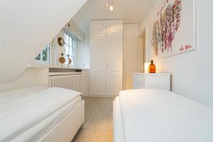 um quarto branco com 2 camas e uma janela em Traumblick App 4 em Munkmarsch