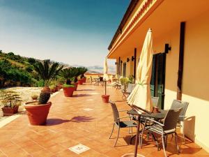 eine Terrasse mit Stühlen und einem Tisch mit einem Sonnenschirm in der Unterkunft Villa della Mimosa in Alia
