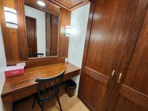 a wooden desk with a mirror and a chair at House of Joe - Camp Johnhay in Baguio