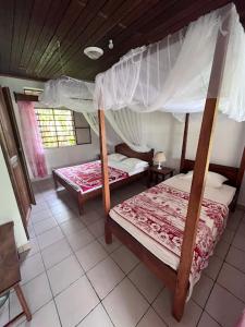 a bedroom with two bunk beds in a room at Residence Monique in Ile aux Nattes