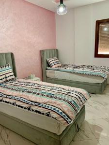 two beds sitting next to each other in a room at appartement équipé in Tangier